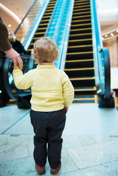 Little girl standing in front of escalator - 写真・画像