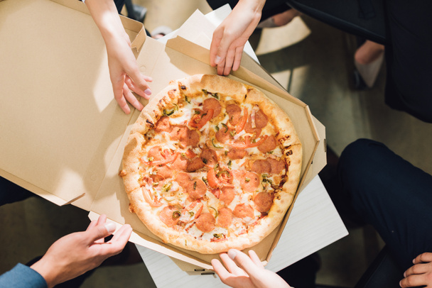 částečný pohled shora spolupracovníků, jíst pizzu v úřadu  - Fotografie, Obrázek