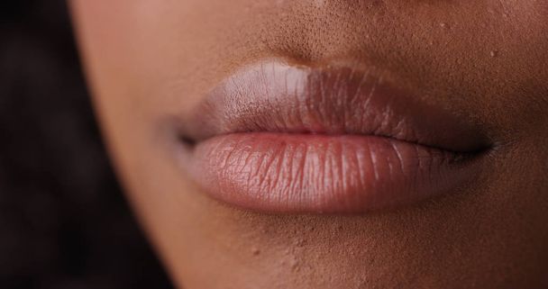 Extremo primer plano de los labios atractivos de la hembra negra en la pantalla verde
 - Foto, imagen