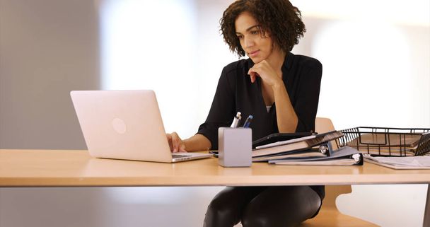 Приваблива бізнес-леді, що працює на ноутбуці в офісі
 - Фото, зображення