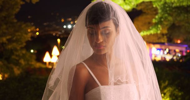 Sposa arrossendo in abito da sposa e il velo posa per il ritratto di notte
 - Foto, immagini
