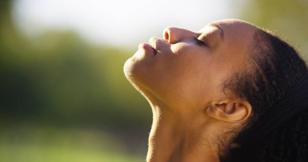 Hermosa mujer negra sintiendo el sol en su cara
 - Foto, imagen
