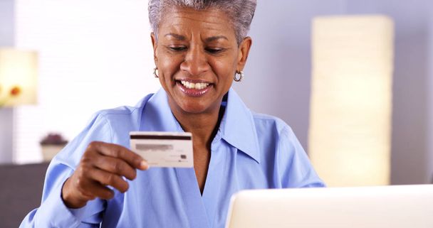 feliz maduro preto mulher digitando no cartão informações
 - Foto, Imagem
