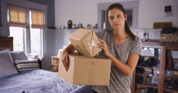 Beautiful Caucasian woman in bedroom carrying boxes to be shipped - Photo, Image