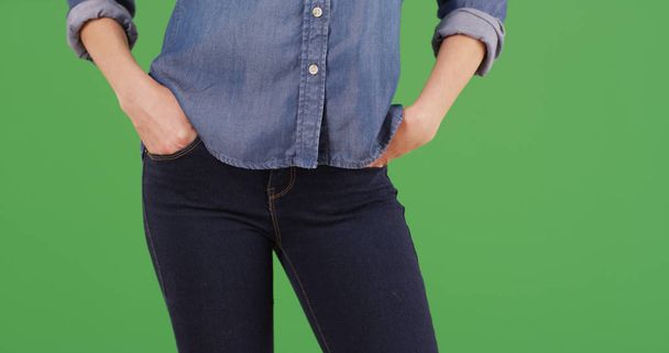Mujer caucásica de pie con las manos en los bolsillos de jean en la pantalla verde
 - Foto, Imagen