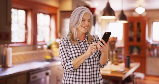 Lovely mid aged woman texting on cell phone device - Photo, Image