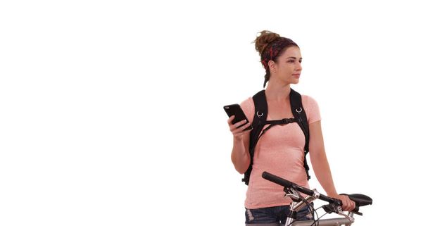 Portrait of Caucasian woman sending text next to bicycle on white background - Foto, Bild
