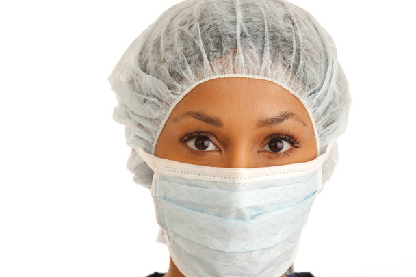 Primo piano di chirurgo donna con maschera e retina per capelli su sfondo bianco
 - Foto, immagini