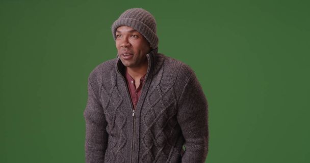 homem afro-americano frio em gorro e suéter na tela verde
 - Foto, Imagem