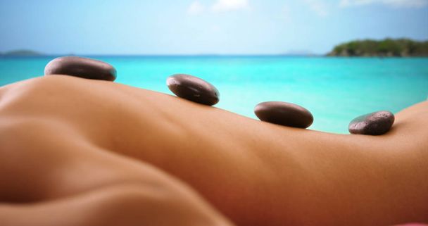 Close up ritratto di donna hanno massaggio con pietre calde sulla spiaggia di caraibi
 - Foto, immagini