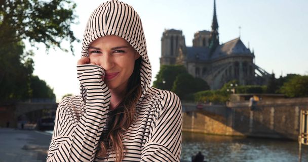 白人女性がパリの旅行バック グラウンドでノートルダム寺院と喜んでポーズ - 写真・画像