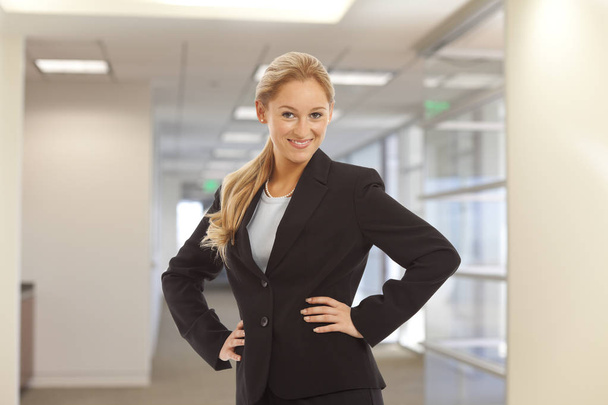 Porträt eines jungen Mädchens im Business-Anzug, das in einem Bürogebäude steht - Foto, Bild