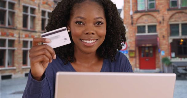 Умная финансово независимая черная женщина держит кредитку и улыбается
 - Фото, изображение