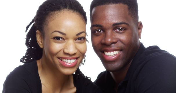 glücklich lächelndes junges schwarzes Paar blickt in die Kamera auf weißem Hintergrund - Foto, Bild