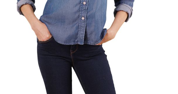 Primer plano de la mujer caucásica poniendo sus manos en los bolsillos de jean delanteros en el estudio
 - Foto, Imagen