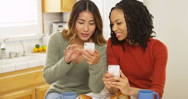 Two women best friends using smart phones and eating breakfast - Fotoğraf, Görsel