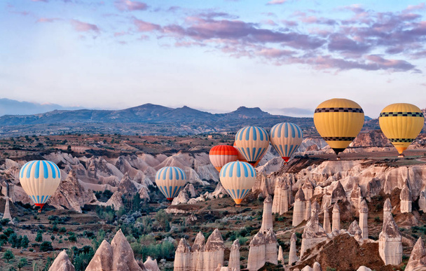 Colorful Hot air balloons flying over mountain landscape in Cappadocia, Goreme National Park ,Turkey. - Фото, изображение