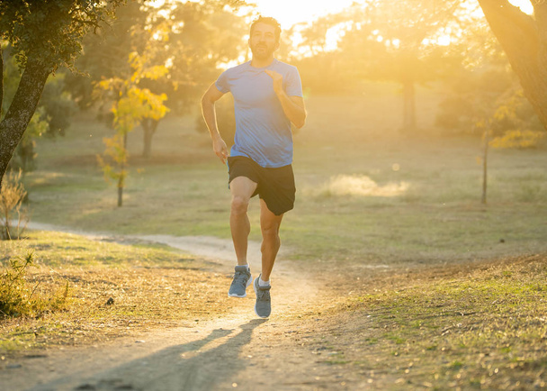Happy runner in sportswear running training for Marathon outside in park at sunset on beautiful summer day in Sports Healthy lifestyle and Jogging Cross Country Training Workout Outdoors concept. - Photo, image