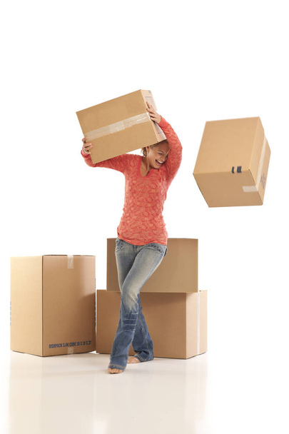 Young woman dropping cardboard boxes - Foto, imagen