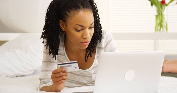 Zwarte vrouw in credit cardnummer te typen - Foto, afbeelding