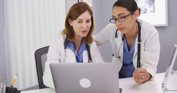 Dos médicos que utilizan la computadora portátil para discutir la condición de salud de los pacientes
 - Foto, Imagen