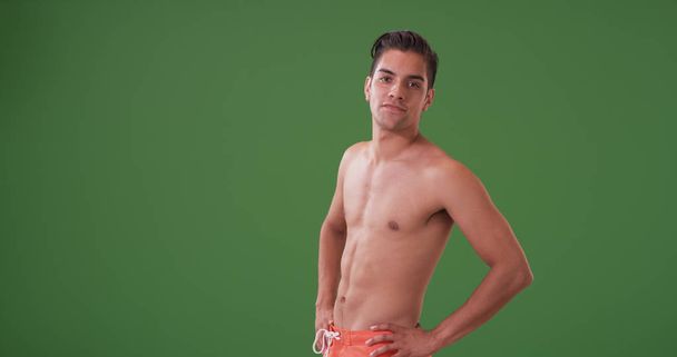 Hombre hispano guapo en bañador posando en pantalla verde
 - Foto, Imagen