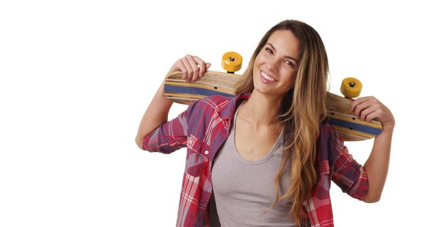 Χιλιετή κορίτσι που θέτουν με skateboard πάνω στους ώμους, στο studio με χώρο αντίγραφο - Φωτογραφία, εικόνα