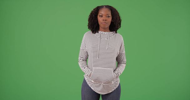 Młodych dorywczo African American kobieta ubrana kobieta z kapturem pozowanie na zielony ekran - Zdjęcie, obraz