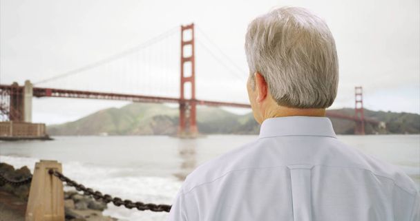 Mid aged male caucasian looking at golden gate bridge in San Francisco bay - Photo, Image
