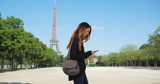 Mooie Kaukasische vrouw in Parijs met behulp van kaart op smartphone - Foto, afbeelding