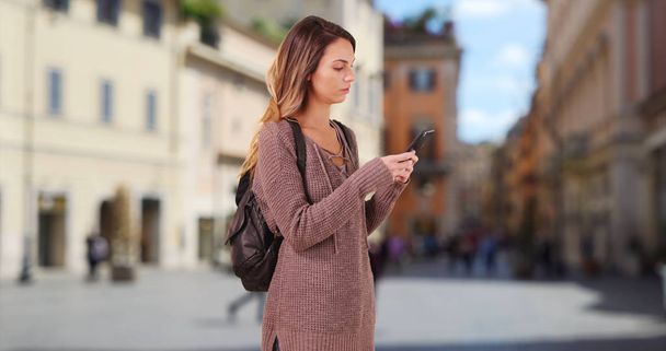 Femme descend la rue Rome en utilisant la carte sur smartphone pour obtenir des directions
 - Photo, image
