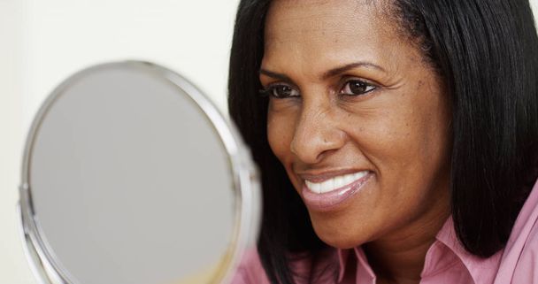 Portrait of African American woman smiling at a mirror - Foto, Imagem