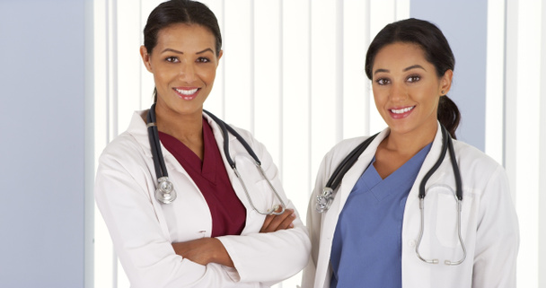 Афроамериканские и латиноамериканские врачи улыбаются в больнице
 - Фото, изображение