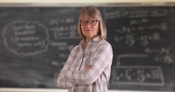 Pewnie kobieta Starszy nauczyciel z rękami skrzyżowanymi stojącą przed chalkboard - Zdjęcie, obraz