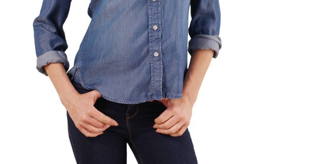 Primer plano de la mujer caucásica enganchando pulgares en el cinturón bucle de jeans en el estudio
 - Foto, Imagen
