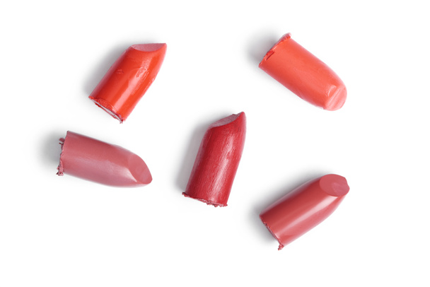top view of cut lipsticks on different colors on white backdrop - Photo, Image