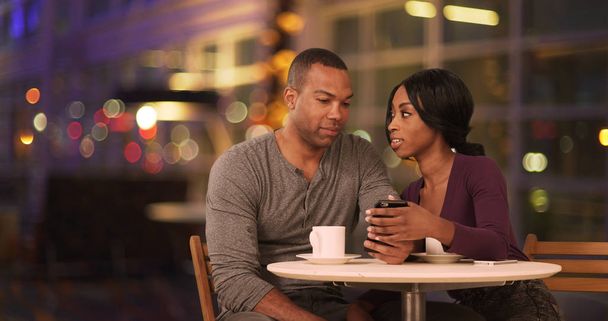 Šťastný pár černých pomocí chytrého telefonu v kavárně v noci - Fotografie, Obrázek