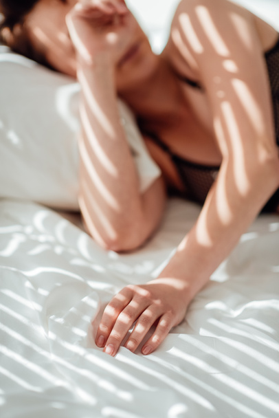 partial view of woman in black underwear sleeping in bed - 写真・画像