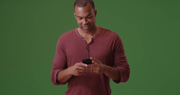 Černoch texty na svém mobilním telefonu na zelené obrazovce - Fotografie, Obrázek