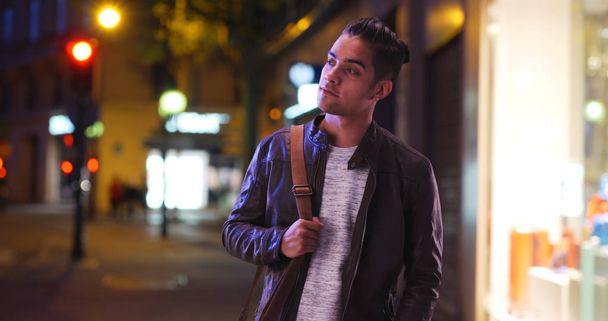 hispanische Millennial-Mann Blick über die Straße in der Stadt bei Nacht - Foto, Bild