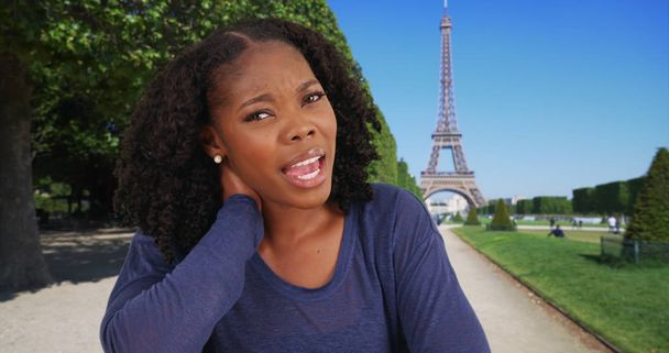 POV schot van zwarte vrouw in de buurt van Eiffel tower video chatten arts over nekpijn - Foto, afbeelding