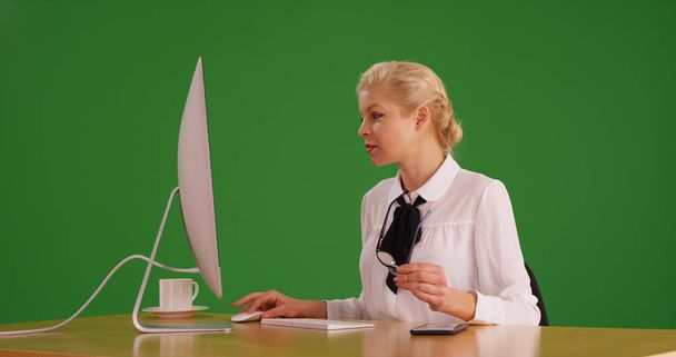Donna d'affari con occhiali che lavora su desktop su schermo verde
 - Foto, immagini