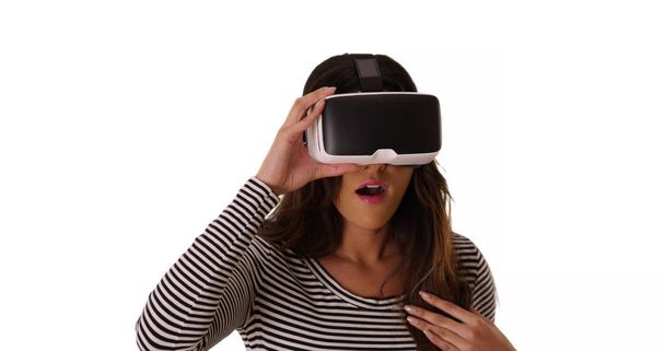 Mulher latina bonito usando óculos de realidade virtual no estúdio espantado com o que ela vê
 - Foto, Imagem
