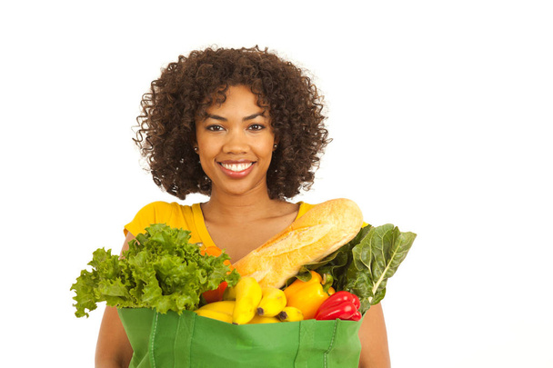 Feliz joven negro milenial mujer sosteniendo comestibles sobre fondo blanco
 - Foto, Imagen