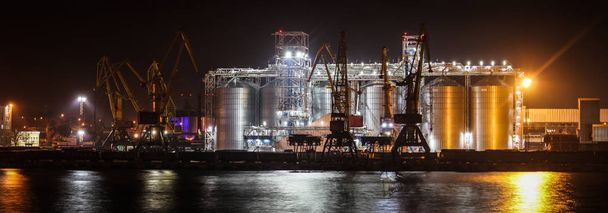 Погрузка зерна в порт. Ночной панорамный вид порта, кранов и другой портовой инфраструктуры
. - Фото, изображение