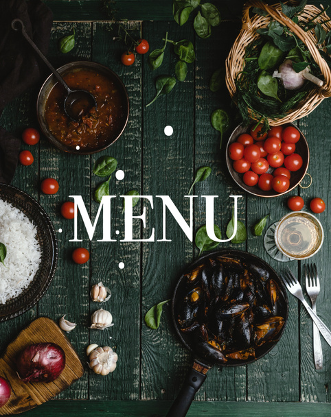 Draufsicht auf gekochte Muscheln mit Schalen, serviert in Pfanne mit Tomaten, Kräutern und Wein auf Holztisch, Menüaufdruck - Foto, Bild