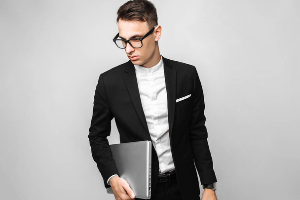 Business man in suit and glasses with laptop isolated on gray background. Business concept - Fotoğraf, Görsel