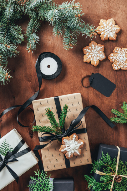 pose plate avec coffrets cadeaux de Noël, rubans, branches de sapin et biscuits flocons de neige sur fond en bois
 - Photo, image