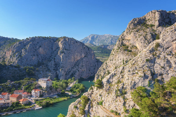 Город Омиш, каньон реки Цетина и скалистые горы Динара, вид сверху с крепости Мирабелла (Пеовица), средиземноморский туристический курорт в Далмации, Хорватия
 - Фото, изображение