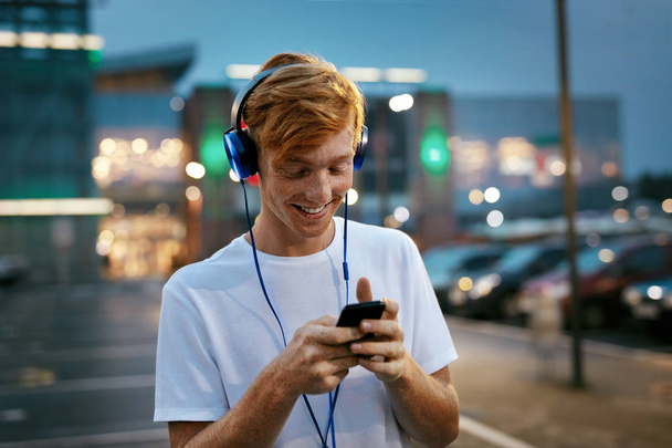 People Technology. Man Listening Music In Headphones With Phone - Valokuva, kuva
